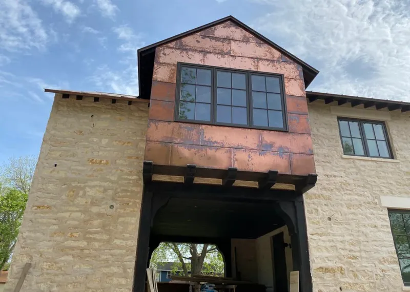 Copper metal panel facade on a stone building for Roof Repair in Roxborough Park